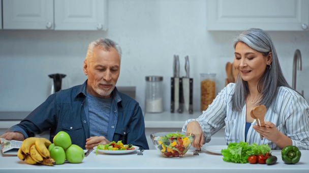 senior interracial pareja teniendo almuerzo en cocina
  - Imágenes, Vídeo