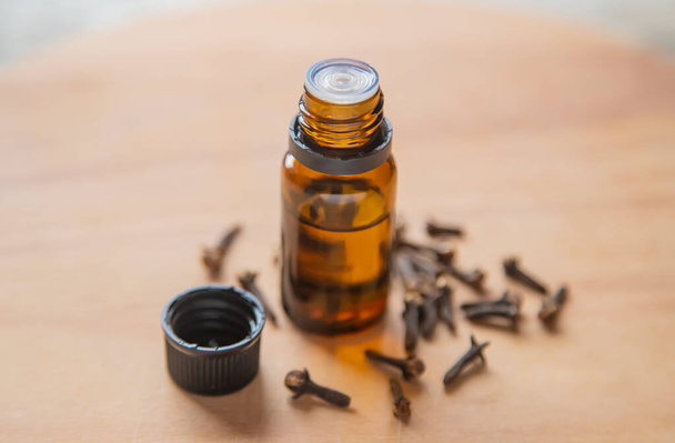 Clove essential oil in a small bottle. Selective focus. - Photo, Image