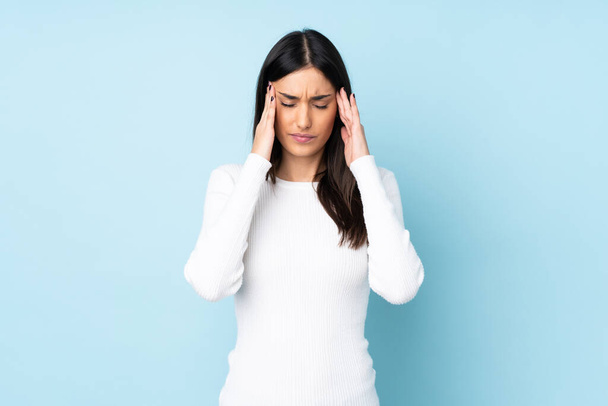 Young caucasian woman isolated on blue background with headache - Photo, Image