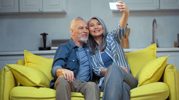 Focus pull van gelukkig senior interraciale paar nemen selfie  - Video