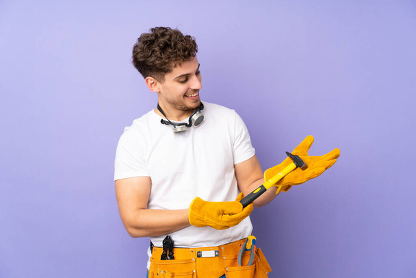 Young electrician man over isolated on purple background - Photo, Image
