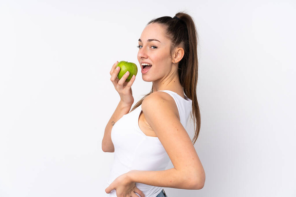 Jeune femme brune sur fond blanc isolé mangeant une pomme
 - Photo, image