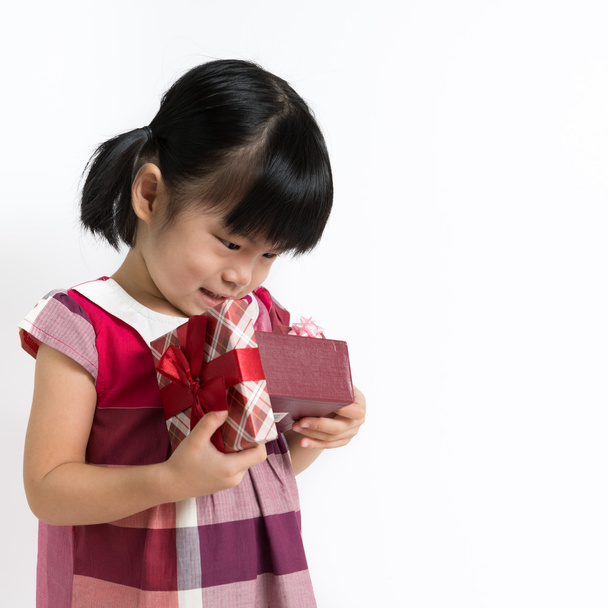 Pieni lapsi lahjapakkauksen kanssa
 - Valokuva, kuva