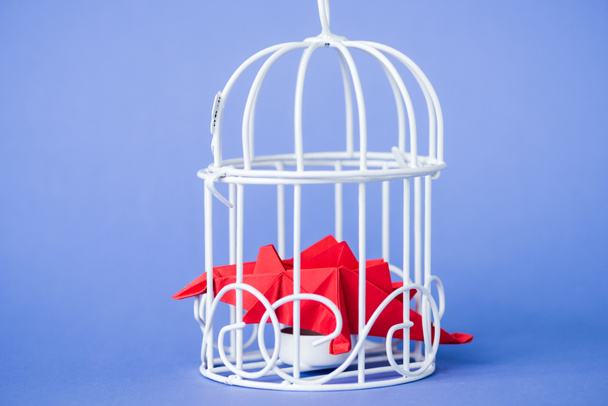 origami birds in metallic cage on blue  - Foto, afbeelding