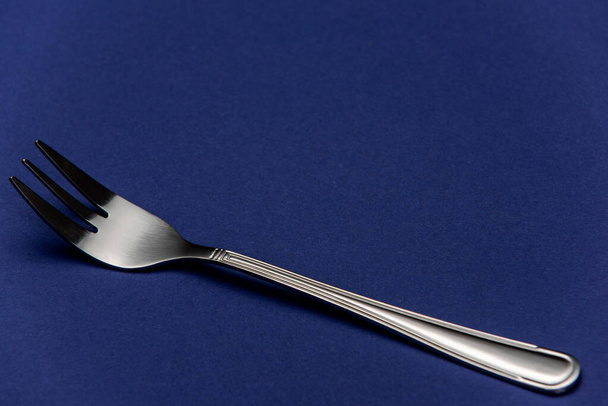 Single One Stainless Steel Fork on Blue Background. Detail Close Up View. - Zdjęcie, obraz