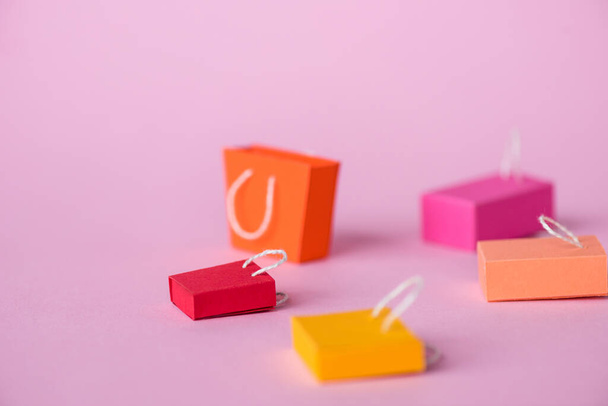 foco seletivo de sacos de compras pequenos e coloridos em rosa com espaço de cópia
  - Foto, Imagem