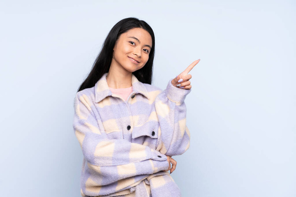 Teenager Chinese woman isolated on blue background pointing up a great idea - Φωτογραφία, εικόνα