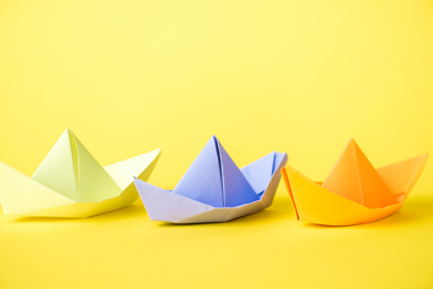 colorful paper ships on yellow with copy space  - Foto, afbeelding