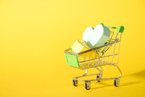 origami hearts in toy shopping cart on yellow  - Фото, зображення