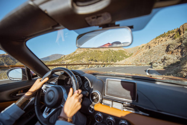 Mujer conduciendo un cabriolet en el camino de la montaña
 - Foto, imagen