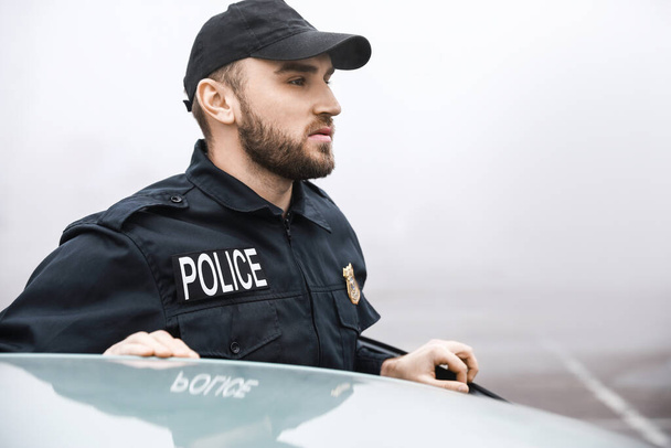 policial masculino perto de carro ao ar livre
 - Foto, Imagem