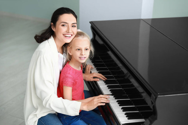 Privater Musiklehrer gibt Klavierunterricht für kleines Mädchen - Foto, Bild
