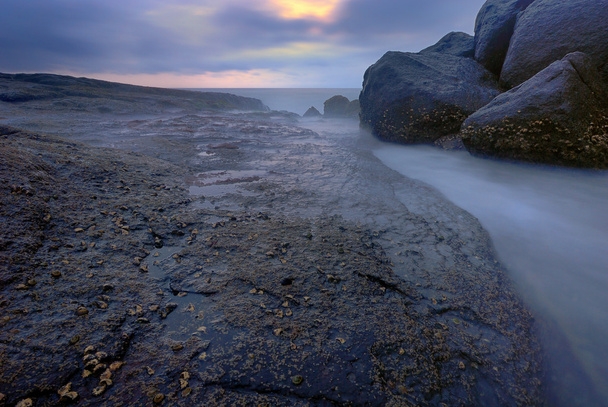 Πετρώματα με μια ήρεμη μπλε θάλασσα - Φωτογραφία, εικόνα