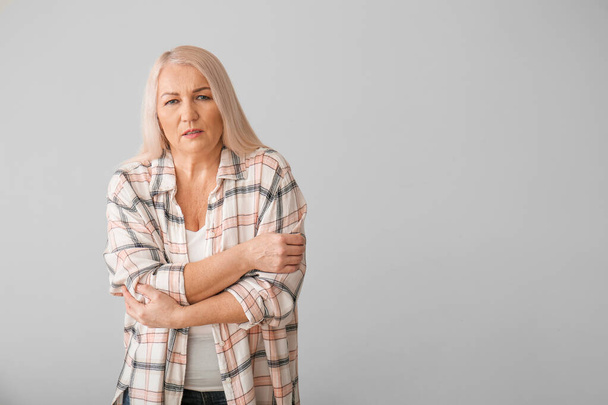 Seniorin mit Parkinson-Syndrom auf grauem Hintergrund - Foto, Bild