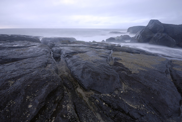 Πετρώματα με μια ήρεμη μπλε θάλασσα - Φωτογραφία, εικόνα