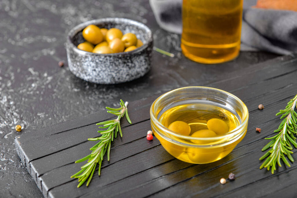 Bol d'huile d'olive savoureuse sur fond sombre
 - Photo, image