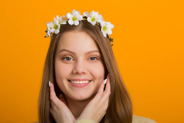 beautiful young woman with a wreath on her head on a yellow background - Foto, imagen