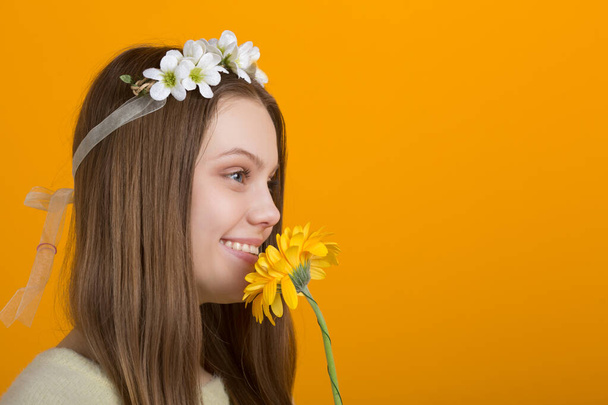 beautiful young woman with a wreath on her head on a yellow background - Fotoğraf, Görsel