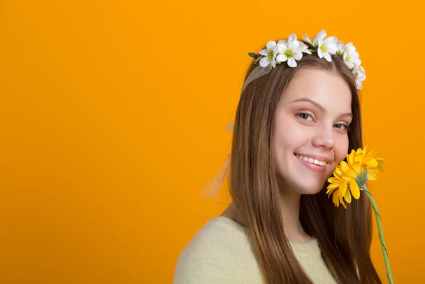 beautiful young woman with a wreath on her head on a yellow background - Valokuva, kuva