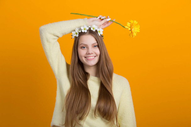 beautiful young woman with a wreath on her head on a yellow background - Zdjęcie, obraz