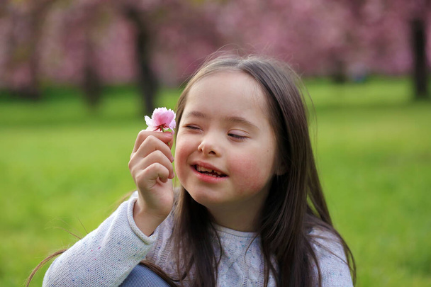 Dziewczyna w parku kwitnącej sakury - Zdjęcie, obraz