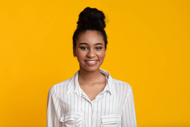 Portrét usmívající se mladé africké americké ženy dívající se do kamery - Fotografie, Obrázek