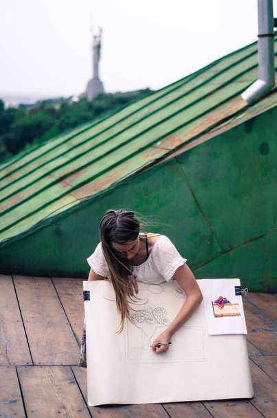 Watercolor artist painting on the roof. Filmed on retro soviet lens helios 44 m. - Zdjęcie, obraz