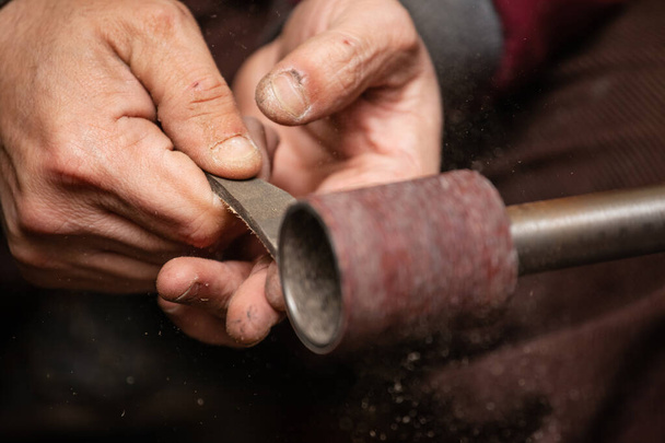 primer plano de las manos masculinas de un trabajador moliendo una pieza en una máquina
 - Foto, imagen