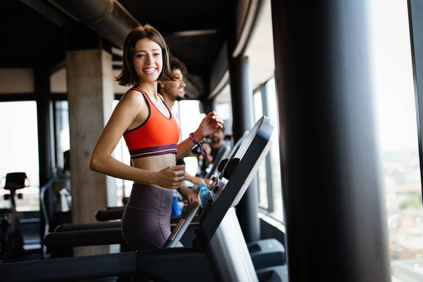 Group of young people running on treadmills in modern sport gym - Valokuva, kuva