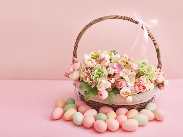 Spring holiday concept with copy space. Template Easter Greeting Card. Easter eggs and flowers . Easter decoration with eggs. Easter basket with flowers and eggs on pink background. - Foto, immagini