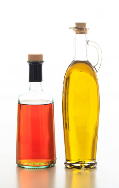 Olive oil and vinegar bottles isolated. Transparent glass bottles with cork stopper isolated against white background. Extra virgin olive oil and red wine vinegar - Photo, Image