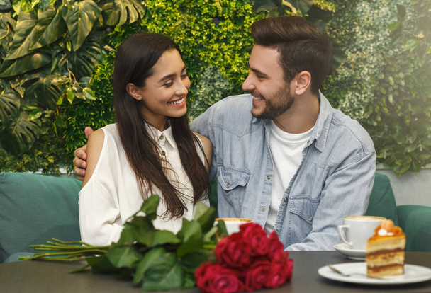 恋人は座っていると居心地の良いカフェテリアでロマンチックなデートに抱擁 - 写真・画像