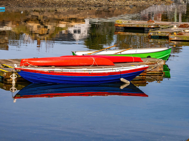 水面に映る赤青と緑のボートは - 写真・画像