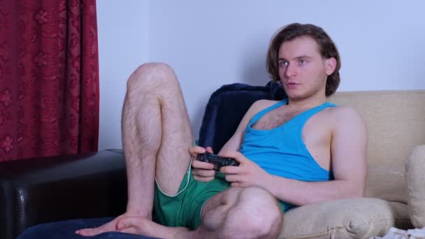 Concentrated young man playing video game at home - Video