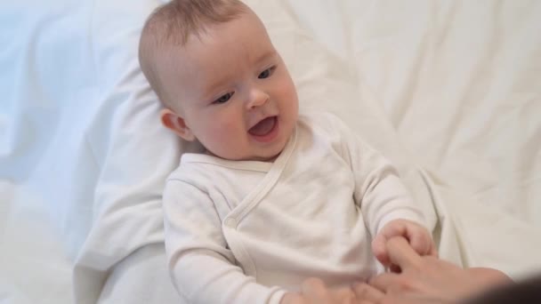 tickling. baby is lying on mum feet and looks up - Video