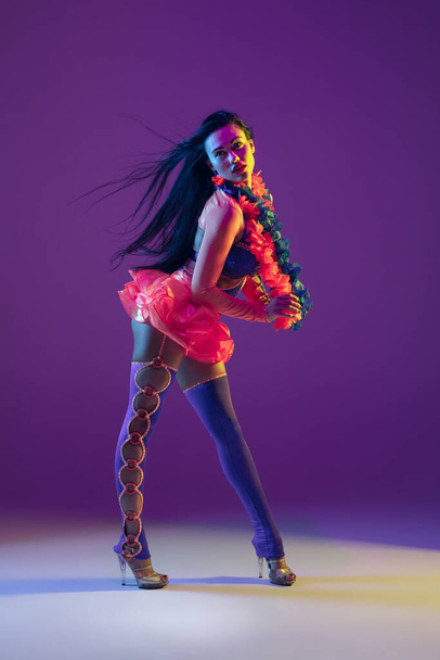 Attractive hawaiian brunette model on purple studio background in neon light - Photo, Image
