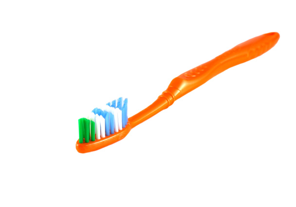 Cepillo de dientes naranja sobre blanco
 - Foto, Imagen