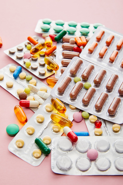 Focus selettivo di farmaci colorati su sfondo rosa
 - Foto, immagini