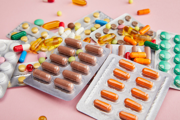 Selective focus of colorful capsules and pills on pink - Photo, Image