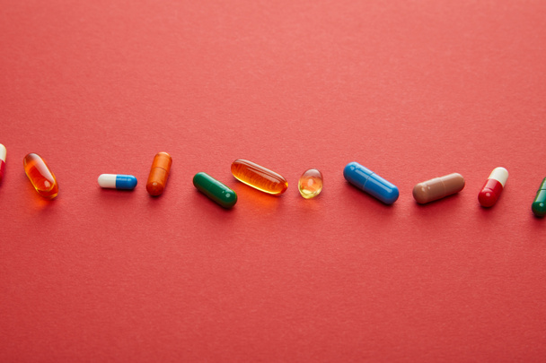 High angle view of pills on red background - Photo, Image