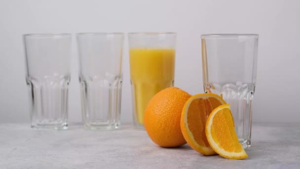 Pyszny, zdrowy, schłodzony sok pomarańczowy wlewający się do szkła. Świeży napój wegetariański - Materiał filmowy, wideo