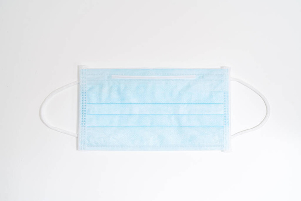Surgical mask with rubber ear straps. Typical 3-ply surgical mask to cover the mouth and nose. Procedure mask from bacteria. Protection concept. - Photo, Image