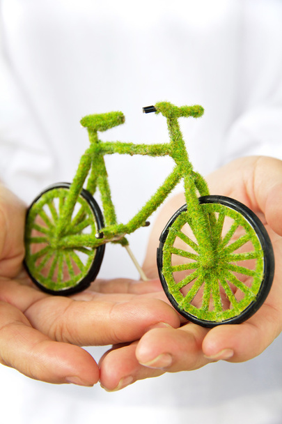 Рука тримає зелений велосипед
 - Фото, зображення