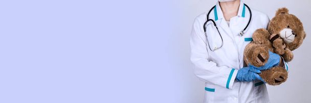 Женщина-врач педиатр держит плюшевого мишку
 - Фото, изображение