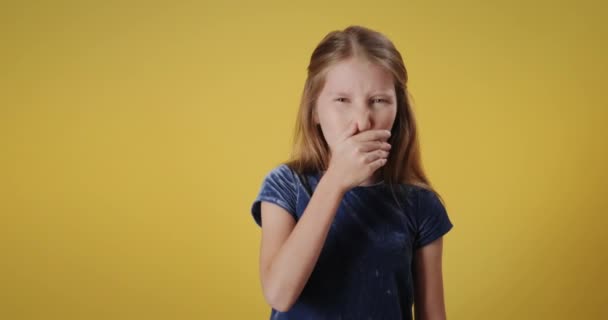 Portrait of disgusted caucasian little girl, looking at camera. Redhead female child with emotions and feelings of disgust for bad smell. Copy space - Footage, Video