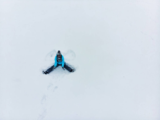 yleisnäkymä nainen tekee lumi enkeli talvikaudella - Valokuva, kuva