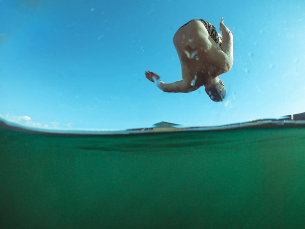 людина стрибає з дерев'яного пірсу в озерній воді літній час
 - Фото, зображення