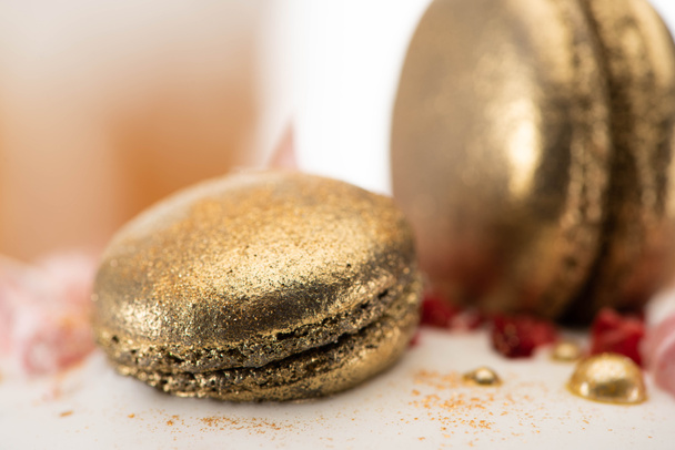 close up view of delicious easter cake with golden french macaroons - Foto, afbeelding