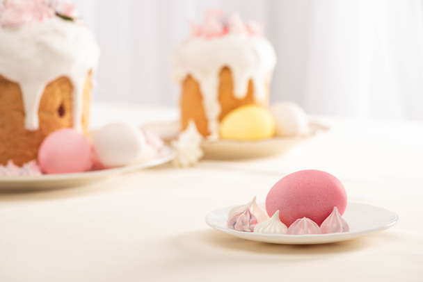 selective focus of delicious Easter cakes, meringue and colorful eggs  - Zdjęcie, obraz