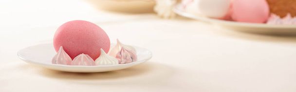 pink painted Easter egg with meringue on plate, panoramic shot - Fotoğraf, Görsel